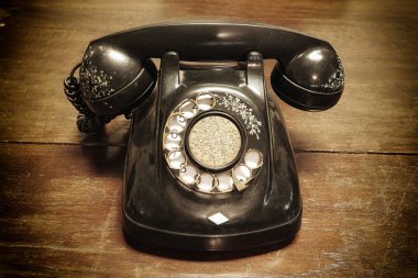 old telephone with rotary dial on old wooden clipart