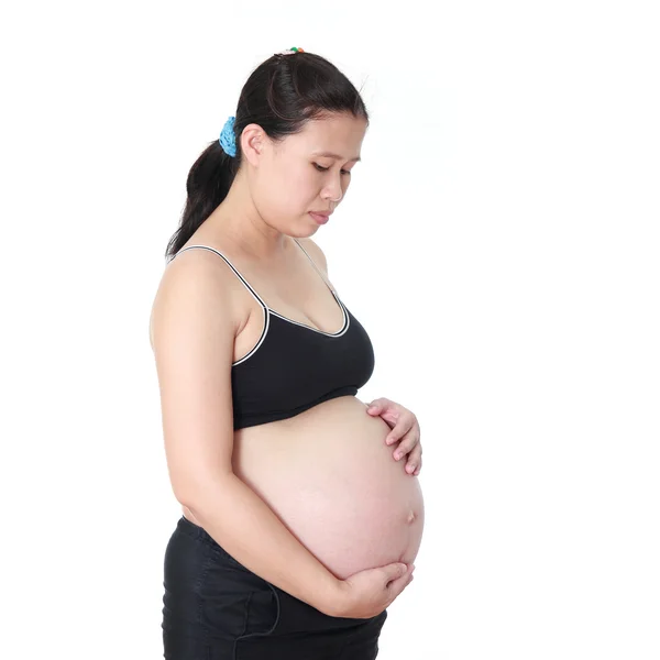 Schwangere Frau streichelt ihren Bauch auf weißem Hintergrund — Stockfoto