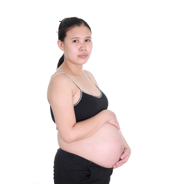 Gravid kvinna smeker magen på vit bakgrund — Stockfoto