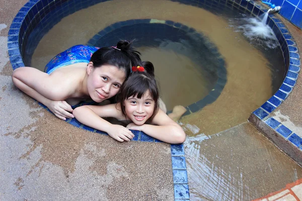 Menina adorável e sua mãe na piscina de água termal — Fotografia de Stock