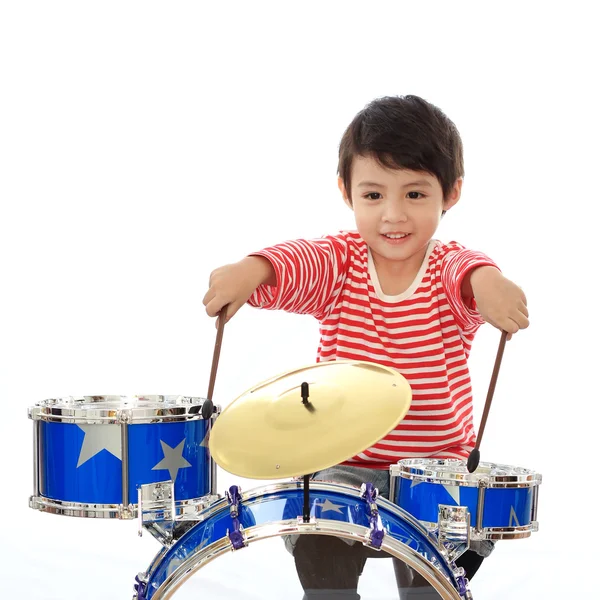 Азиатский мальчик играет на голубом барабане на белом фоне — стоковое фото