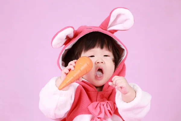 Bébé habillé en oreilles de lapin de Pâques avec carotte — Photo