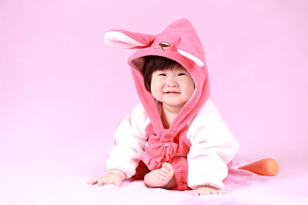 Dítě oblečené v uši Velikonoční zajíček s mrkví — Stock fotografie