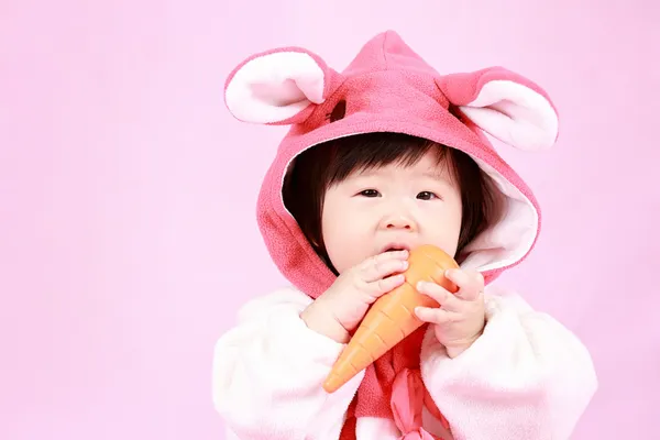 Bebé vestido con orejas de conejo de Pascua con zanahoria — Foto de Stock