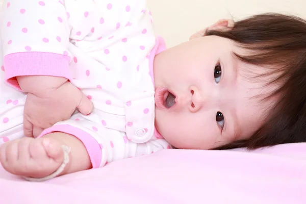 Meisje van de baby op het bed — Stockfoto