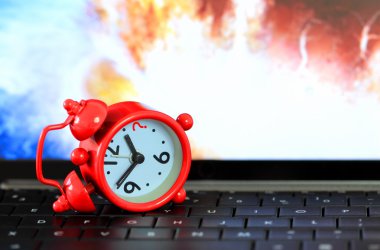klavye ile dünya boom arka plan üzerinde kırmızı alarm saati.