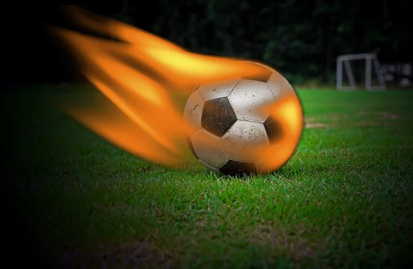 Football burning on green grass — ストック写真