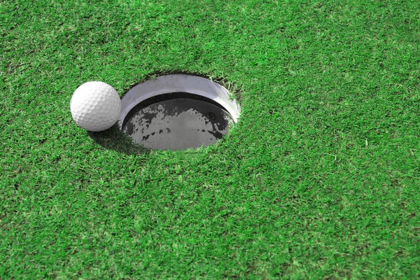 Golfball geht ins Loch — Stockfoto