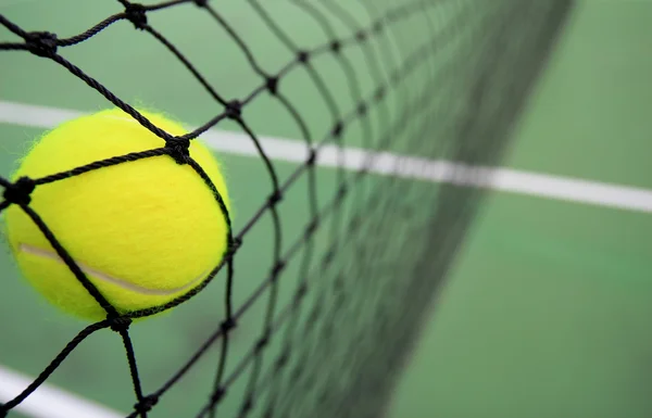 Tennis ball in net — Stock Photo, Image