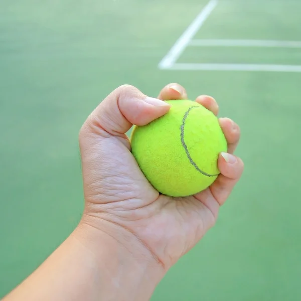 Теннисный мяч в руке — стоковое фото