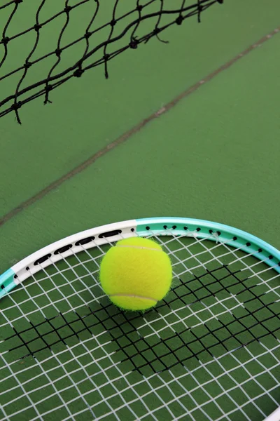 Tennis ball and racket on tennis court — Stock Photo, Image