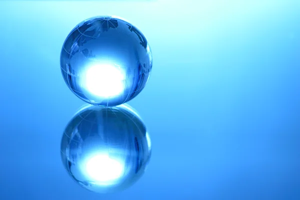 Blue glass globe on mirror — Stock Photo, Image