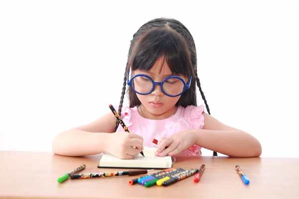 Asian little girl draw on a book isolated on a over white backgr — Stock Photo, Image