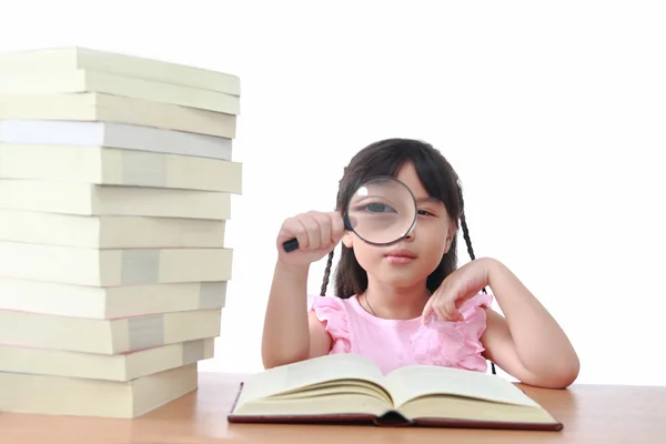 Asyalı küçük kız büyüteç ile izole kitap okuma — Stok fotoğraf