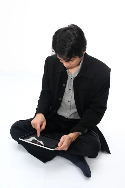 Iş adamı rahat oturan bir dijital tablet ile — Stok fotoğraf