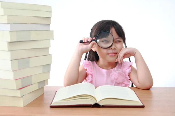 Student little girl reading with magnifying glass — Stock Photo, Image