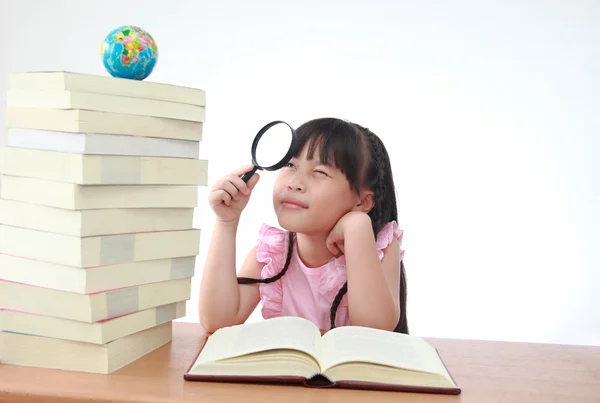 Student little girl reading with magnifying glass look the globe — Stock Photo, Image