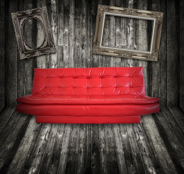 Sofa meubilair in houten kamer met fotolijstjes — Stockfoto