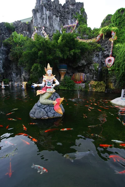 Estatua de sirena estilo tailandés en el lago con peces de carpa —  Fotos de Stock