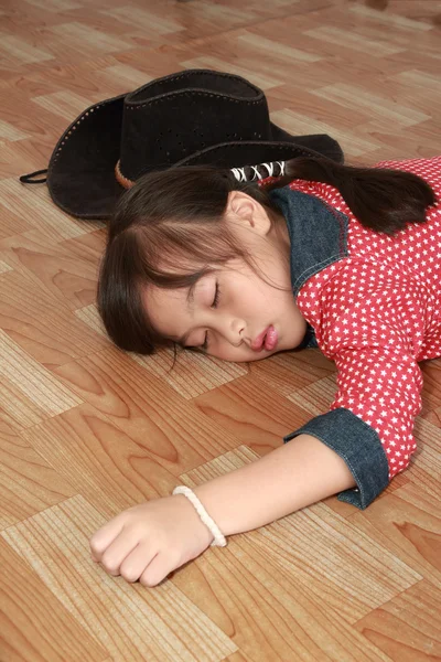 Unga cowgirl sova på golvet — Stockfoto