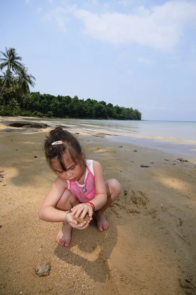 Asiatische Mädchen spielen in sand. — Stockfoto
