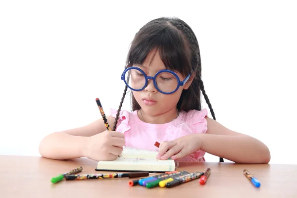 Asiatische kleine Mädchen zeichnen auf ein Buch — Stockfoto