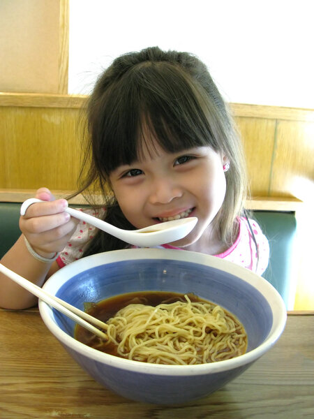 Asian young girl eating noodle