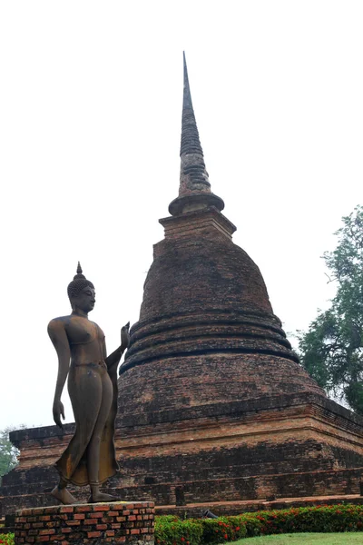 Bouddha debout dans le parc historique de Sukhothai avec la pagode en arrière-plan — Photo