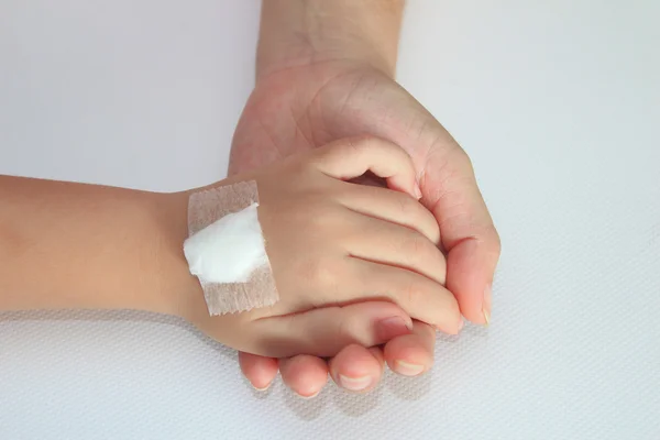 Main d'enfant avec bandage sur la main de sa mère — Photo