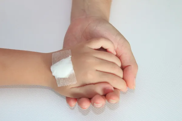 Crianças mão com bandagem em sua mão mãe — Fotografia de Stock