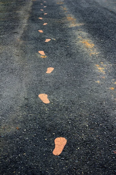 Yürüyüş üzerinde sarı footmarks izlemek — Stok fotoğraf