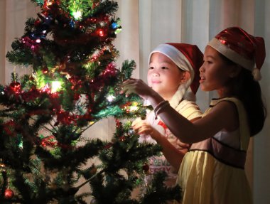 Noel ağacı süsleyen mutlu kızın portresi
