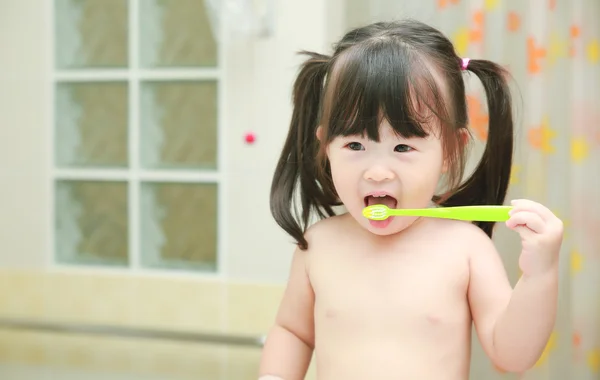 Klein meisje borstelen tanden in Bad — Stockfoto
