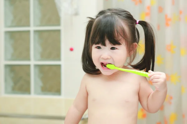 Niña cepillándose los dientes en el baño — Foto de Stock