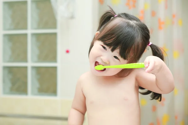 Little girl brushing teeth in bath — Stock Photo, Image