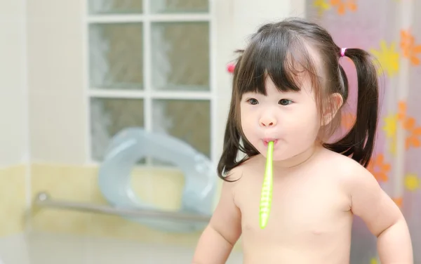 Little girl brushing teeth in bath — Stock Photo, Image