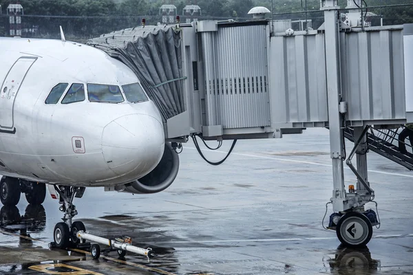 Самолет в аэропорту под дождем — стоковое фото