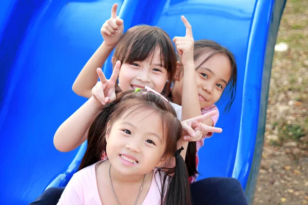 Tre glada leende barn leker i parken — Stockfoto