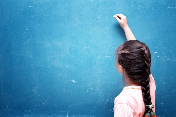 Girl drawing on blank chalkboard — Stock Photo, Image