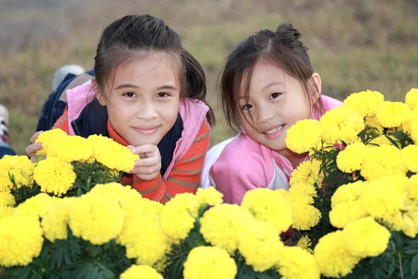 Pouco menina asiática em um jardim de flores — Fotografia de Stock