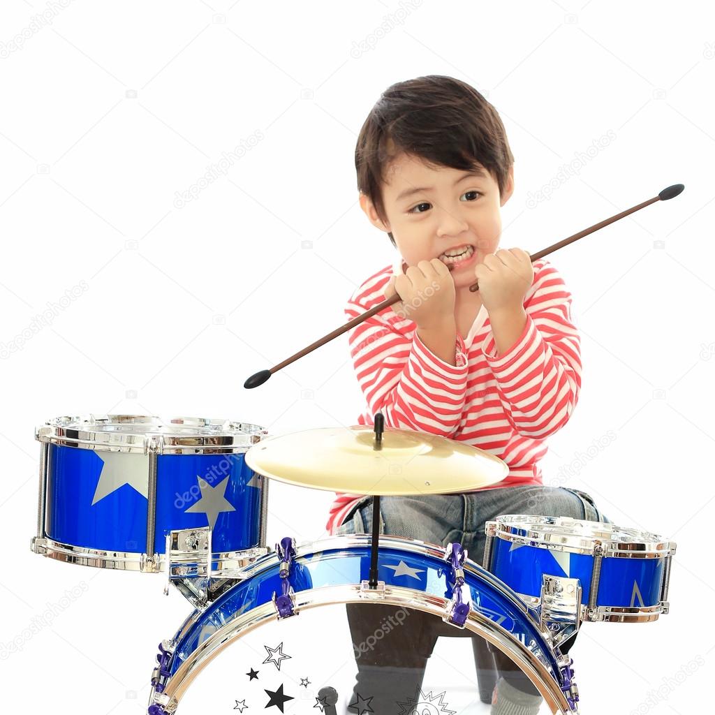 Asian young boy playing drum on white background