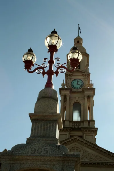 Laternenpfahl und Uhrturm — Stockfoto