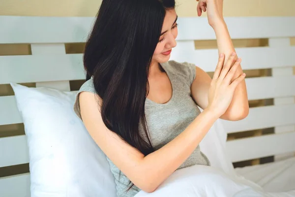 asian woman use lotion hands cream moisture and white moisturize lotion on bed in bedroom, therapy beauty, skin care concept.