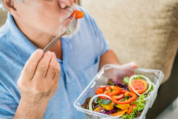 Mature man with pumpkin and healthy food, Portrait Asian Senior man eating a salad in house, Old elderly male health care eat vegetables and useful foods.