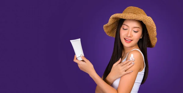 Beautiful asian woman showing cream on her hand and put some cream on arm with fingers.  protection sunshine with sun screen cream or anti age treatment copy space for your advertisement.