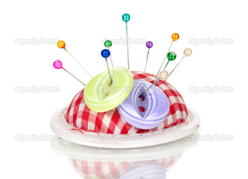 Colored pinheads in pin-cushion and button isolated on white