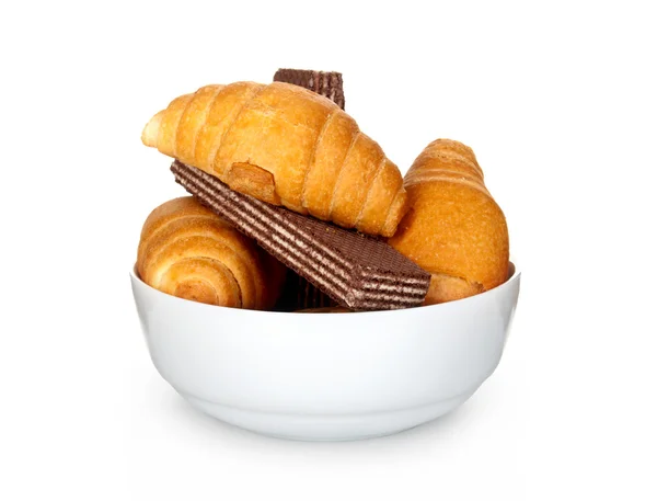 Croissanty a oplatky na desce izolovaných na bílém pozadí — Stock fotografie