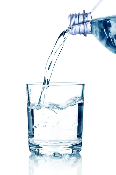 Wasser auf ein Glas auf weißem Hintergrund gießen Stockbild