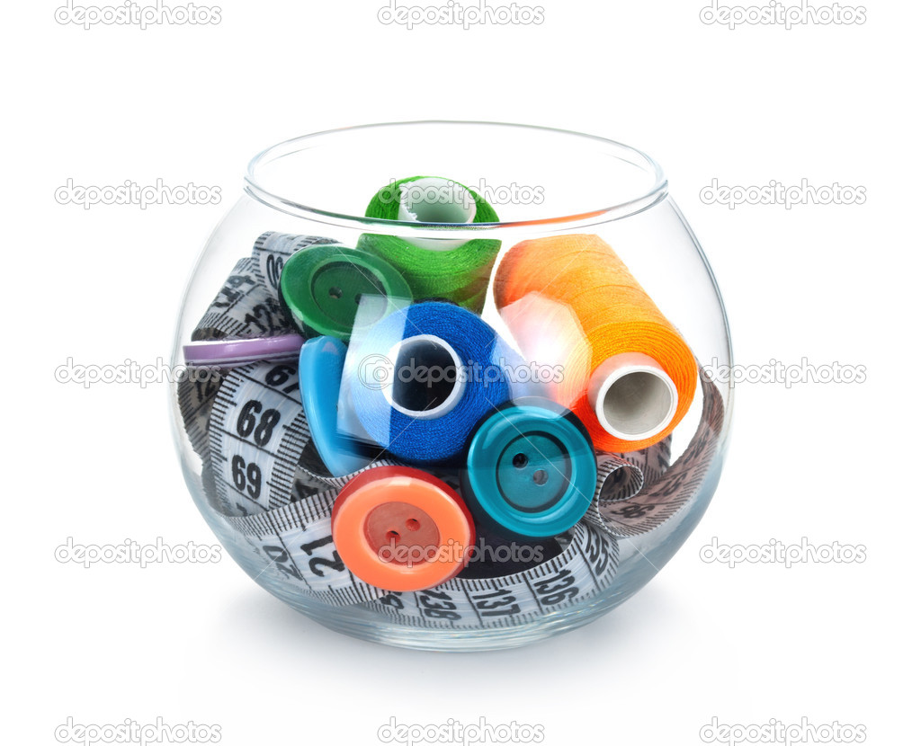 Glass jar with buttons, tape measuring and skeins of thread on white background