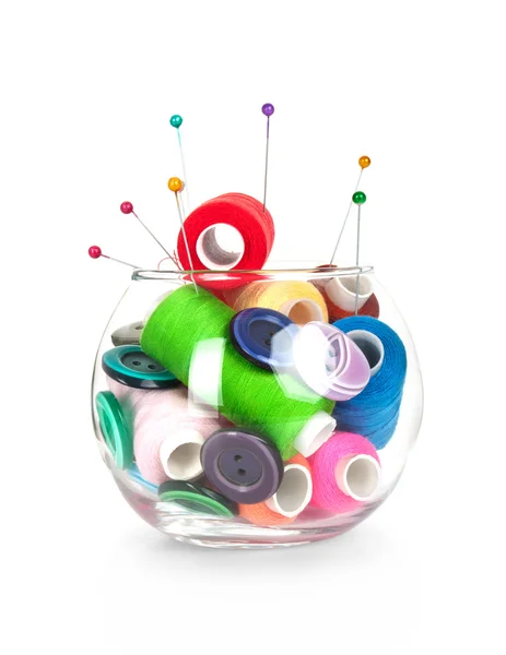 Glass jar with buttons,needles, tape measuring and skeins of thread on white background — Stock Photo, Image